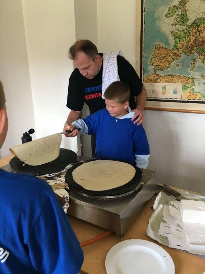 Pandekagebageren viser en gæst, hvordan pandekagen vendes